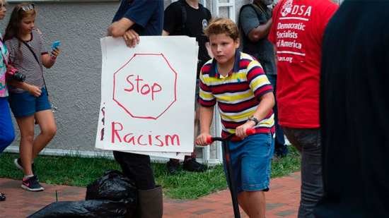 A person holds an anti-racism poster in Lafayette Square in Washington Aug. 12.