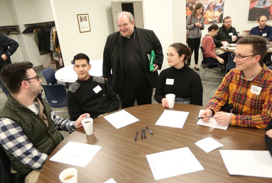 Archbishop Bernard Hebda talks with Tucker Moore, left, of the Basilica of St. Mary in Minneapolis, Christopher Damian of St. Thomas More in St. Paul, Kirby Hoberg of Holy Family in St. Louis Park, and Nathan Cornwell, also of Holy Family, before the start of a listening session for young adults Dec. 10 at the Archdiocesan Catholic Center in St. Paul.