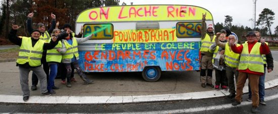 Protesters pose in front of a caravan with the slogan "We give up nothing" as they occupy a roundabout during the "yellow vests" protest against higher fuel taxes Dec. 7 in Cissac-Medoc, France.
