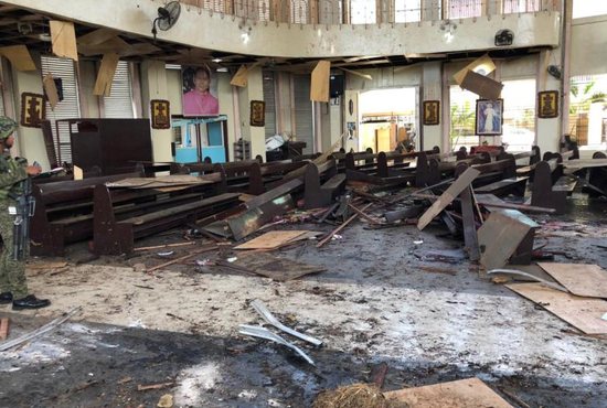 A Philippine army member inspects the damage inside the Cathedral of Our Lady of Mount Carmel in Jolo Jan. 27, 2019.