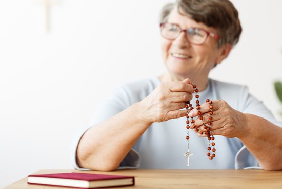 Happy woman praying the rosary