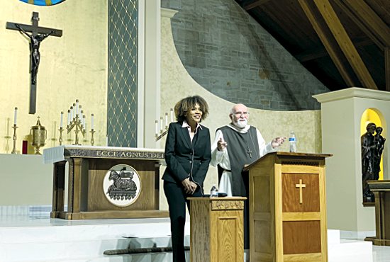 Catherine Sy of Holy Name of Jesus in Wayzata translates for Father Jacques Philippe of the Community of the Beatitudes March 21 at St. John the Baptist in Excelsior. Father Philippe, who is from France, spoke at an evening of reflection on the holiness of the Church.