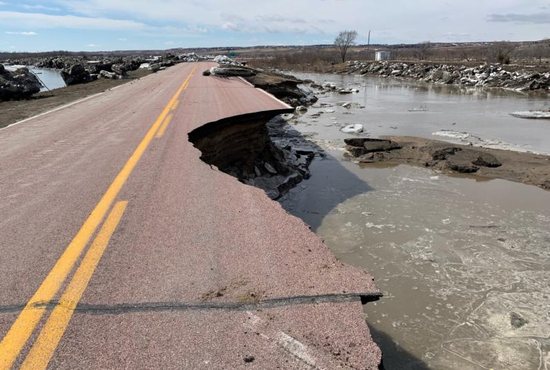 A damaged road is seen March 16, 2019, after a storm triggered historic flooding in Niobrara, Neb. Gov. Pete Ricketts and the Nebraska National Guard surveyed flooded farms, homes, bridges and highways, damage Ricketts called "devastating" and perhaps the worst seen in a half-century.
