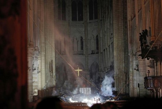 Smoke rises around the altar inside Notre Dame Cathedral in Paris as a fire continues to smolder early April 16, 2019. Officials said the cause was not clear, but that the fire could be linked to renovation work.