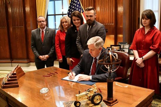 Missouri Gov. Mike Parson signs a bill into law banning abortion beginning in the eighth week of pregnancy, alongside state House and Senate members and pro-life coalition leaders at his office in Jefferson City May 24, 2019. Archbishop Joseph F. Naumann of Kansas City, Kan., chairman of the U.S. bishops' Committee on Pro-Life Activities, in a May 23 statement praised Missouri and other states for passing pro-life legislation in recent weeks. "Every single human life has value," he said.