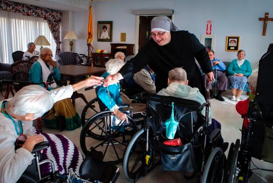 Sister Constance Veit, a Little Sister of the Poor, collects rosaries from elderly residents following prayers at the Jeanne Jugan Residence for senior care in Washington March 25, 2019. Sister Constance is considered a spiritual mother by many of the residents, who said they will honor her on Mother's Day.