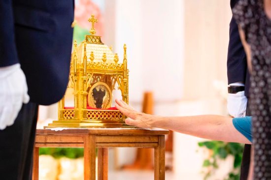 A worshipper venerates a reliquary containing St. John Vianney's incorrupt heart at St. Anne Church in Gilbert, Ariz., May 6, 2019.