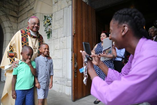 Washington Archbishop Wilton D. Gregory poses with two boys after celebrating Mass at St. Augustine Church in Washington June 2, 2019.