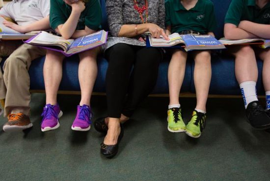 A teacher at Holy Name of Jesus Catholic School in Henderson, Ky., helps third-grade students with a reading lesson March 28, 2019. Catholic bishops in the U.S., England and Wales welcomed the Vatican's statement that gender ideology is opposed to faith and reason, and that Catholic schools and parents must help teach children that gender is fixed from birth. 