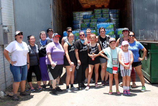Members of the pro-life groups And Then There Were None and New Wave Feminists stand in front of a truck of supplies for migrants