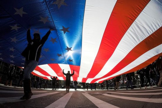 People in New York City carry the U.S. flag