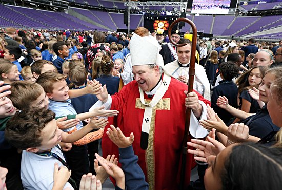 Archbishop Hebda warmly greets elementary school students at a school-focused Mass of the Holy Spirit at U.S. Bank Stadium