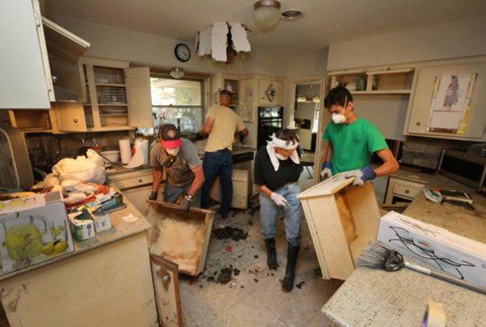 Knights of Columbus rip out waterlogged sections of the kitchen area of a flooded home