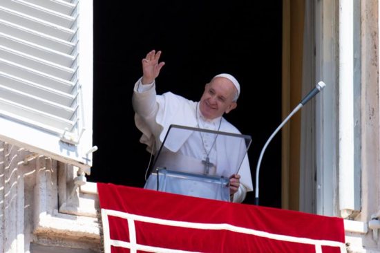 Pope Francis greets the crowd as he leads the Angelus from the window of his studio 