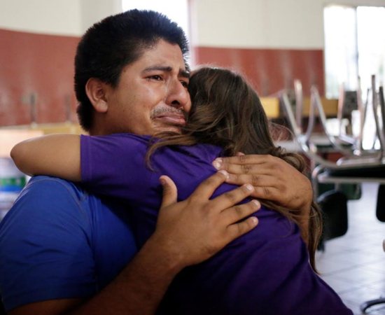 Salvadoran migrant Jose cries as he and his daughter embrace