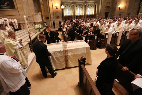 Archbishop Bernard Hebda, left, receives the body of Archbishop Harry Flynn at the start of the funeral Mass