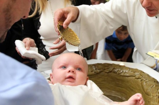 A baby is seen during her baptism.