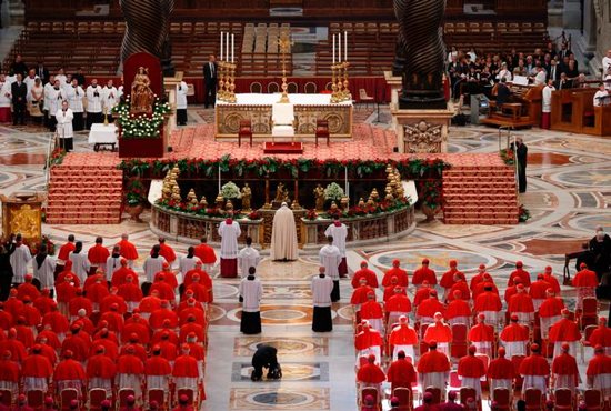 Pope Francis prays as he arrives for a consistory