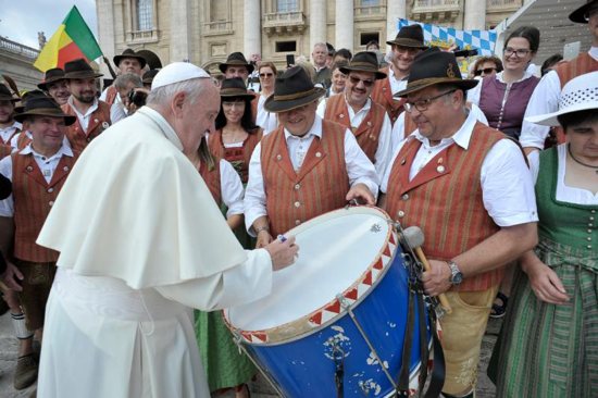 Pope Francis autographs the drum of a pilgrim