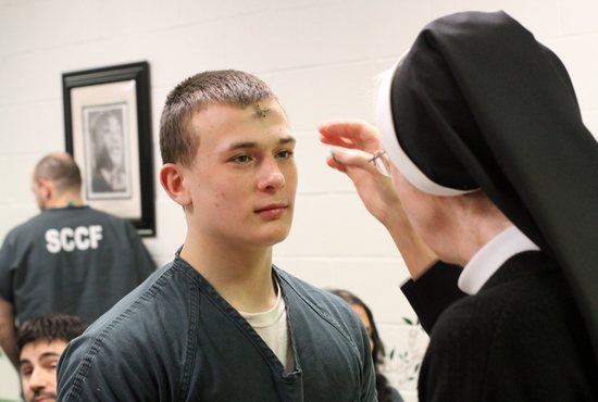 An inmate receives ashes from a nun on Ash Wednesday