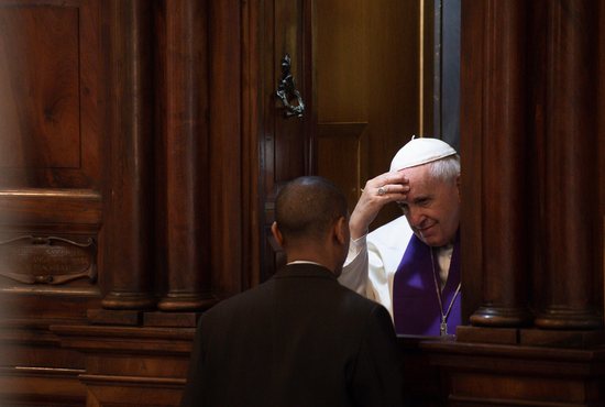 Pope Francis hears the confession of a priest
