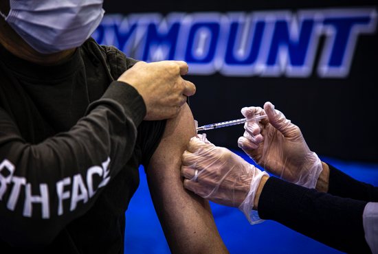 A health care worker administers the Pfizer COVID-19 vaccine to a Marymount University student in one of the athletic buildings on the Catholic college's Arlington, Va., campus, during a coronavirus vaccine clinic April 21, 2021. The clinic, which was the result of a partnership with both Safeway and the Army National Guard, allowed a total of 1,174 individuals to get vaccinated -- exceeding the initial goal of Marymount administrators.