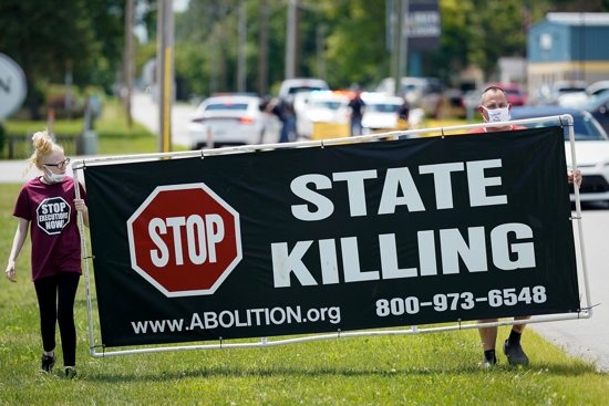 Demonstrators are seen near the Federal Correctional Complex in Terre Haute, Ind., showing their opposition to the death penalty July 13, 2020.