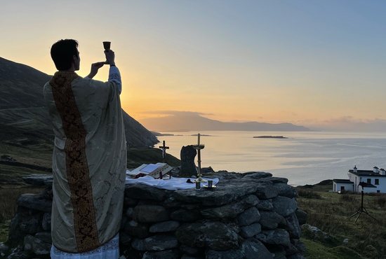 Father Gerard Quirke raises the chalice at Mass Rock overlooking Keem Bay on Ireland's Achill Island April 4, 2021. Father Quirke, a priest of the Archdiocese of Tuam, said celebrating Easter Mass there had a "particular resonance" given the current legal ban on Masses in Ireland. 