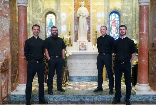 Seminarians who help run the prayer hotline at the National Shrine of St Elizabeth Ann Seton in Emmitsburg, Md., pose for a photo in front of the Altar of Relics in the shrine's basilica April 7, 2021. Pictured from left are Caleb Kruse of Peoria, Ill, and Benedict Radich, Chris Fiest and Caleb Gaeng, all of Washington.