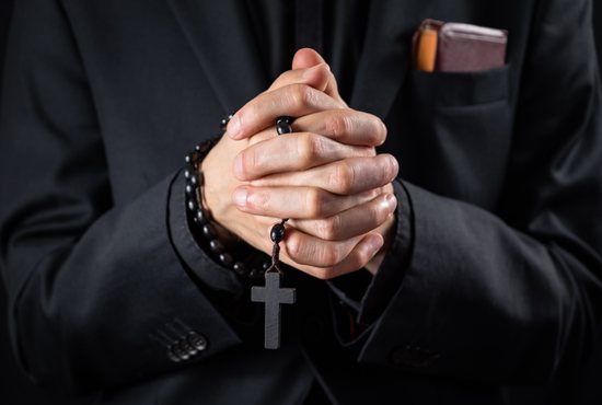 Priest praying rosary