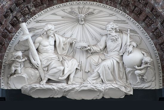 The sculpted pediment (white marble) – representing the Holy Trinity - surmounting the main altar in the Cathedral of Our Lady in Antwerp. This house of worship is the largest Gothic building in the Netherlands. 
