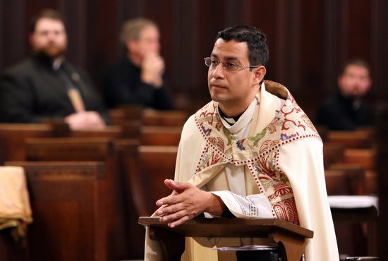 Father Jorge Torres, then vocation director of the Diocese of Orlando, Fla., is seen during eucharistic adoration Oct. 29, 2015, at Immaculate Conception Seminary in Huntington, N.Y. Currently pastor of Our Lady of Lourdes Parish in Melbourne, Fla., Father Torres was appointed June 7, 2021, as a specialist for the U.S. Conference of Catholic Bishops' Secretariat for Evangelization and Catechesis in Washington. In his new role, effective July 12, he will to help implement a planned multiyear National Eucharistic Revival.