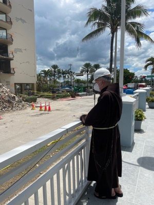 Cardinal Sean P. O'Malley of Boston prays at the site of the partially collapsed Champlain Towers South in Surfside, Fla., which he visited with Archbishop Thomas G. Wenski of Miami July 2, 2021. The parts of the building that remained standing were demolished the night of July 4.