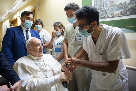 Pope Francis gives a rosary to a member of the medical staff at Gemelli hospital in Rome July 11, 2021, as he recovers following scheduled colon surgery. Earlier the pope led the Angelus from a balcony at the hospital. 