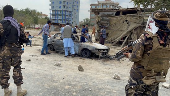 Afghan men take pictures of a vehicle from which rockets were fired, as Taliban forces stand guard in Kabul Aug. 30, 2021. Rocket fire apparently targeting Kabul's international airport struck the nearby neighborhood that day, the eve of the deadline for American troops to withdraw from the country's longest war after the Taliban takeover of Afghanistan.