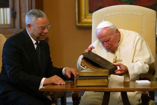 Pope John Paul II opens a gift from U.S. Secretary of State Colin Powell during a private audience at the Vatican June 2, 2003. The former chairman of the Joints Chief of Staff and national security advisory died Oct. 18, 2021, of complications from COVID-19. Powell, who was the nation's first African American secretary of state, was 84. 
