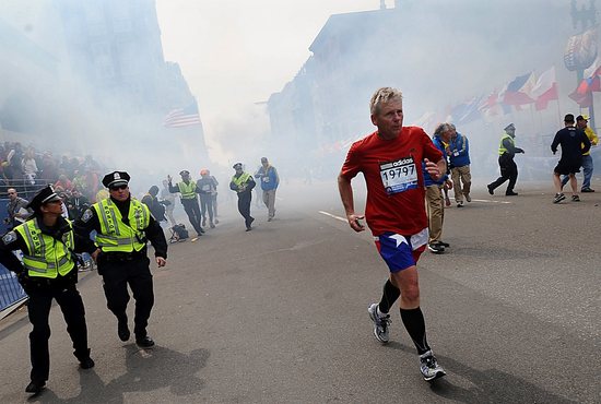 Race officials, police and runners react following two explosions at the Boston Marathon April 15, 2013. Two bombs exploded in the crowded streets near the finish line of the marathon, killing at least three people. More than 140 people were injured.