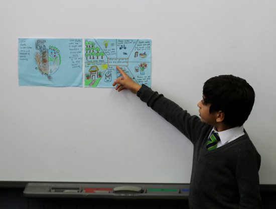 A student points at a poster at St. Conval's Primary School while learning about climate change ahead of the U.N. Climate Change Conference, COP26, in Glasgow, Scotland, Oct. 19, 2021.