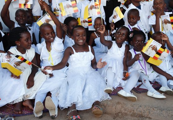 Children sing and wave flags before Pope Francis' meeting with priests, religious and seminarians at the cathedral in Kampala, Uganda, Nov. 28, 2015. Uganda is among countries with projects that benefit from funds raised by the Pontifical Mission Societies, which organizes World Mission Sunday. CNS