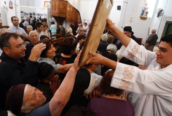 People are pictured in a file photo touching a painting of Mary at St. George's Maronite Catholic Church in Kormakitis, Cyprus. Maronite Father Ibrahim Khita of St. Charbel Church in Limassol said the people are very excited about Pope Francis' Dec. 2-4, 2021, visit to Cyprus.