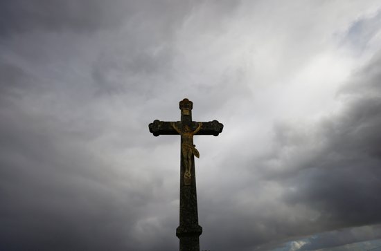 A cross is silhouetted outside a Catholic church near Nantes, France, Oct. 5, 2021. French bishops have unveiled new measures against sexual abuse by clergy in the wake of an independent report released in October.