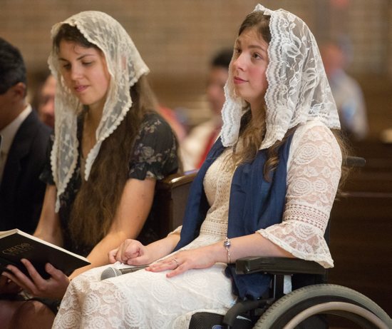 Natasha Sager (foreground) at her first dedication to the Caritas Christi secular institute during Mass Sept. 14 at Epiphany in Coon Rapids. By her side is close friend Samantha Herrlin, a member of Epiphany.