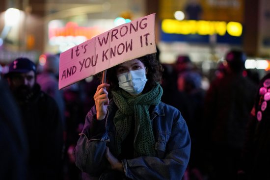 A demonstrator in New York City holds a placard during a protest against the Kyle Rittenhouse verdict Nov. 19, 2021. Rittenhouse was acquitted by a jury that day in the shooting deaths of two people and the wounding of another with an AR-15-style rifle Aug. 25, 2020, during civil unrest in Kenosha over the shooting two days earlier of a Black man, Jacob Blake, by a white police officer. Lawyers for Rittenhouse argued their client acted in self-defense.