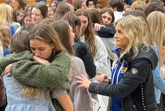 Students at Catholic Memorial High School in Waukesha, Wis., console each other at the sign of peace during a community Mass Nov. 22, 2021. A driver plowed through a holiday parade in the Milwaukee suburb Nov. 21, killing five people at the scene and injuring more than 60 others. On Nov. 23 Jackson Sparks, 8, died at Children's Hospital of Wisconsin as a result of injuries he sustained at the parade, bring the death toll to six.