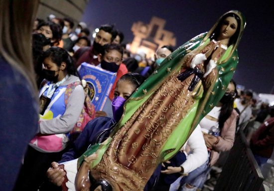 A woman carries a statue of Our Lady of Guadalupe outside the basilica in her name in Mexico City Dec. 11, 2021, the eve of her feast day. Millions of pilgrims descended on the basilica during the first 12 days of December, renewing a tradition and act of faith common throughout central Mexico.