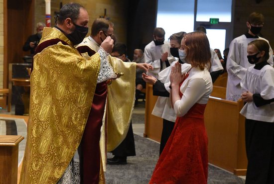 Father Aaron Jenkins, pastor of St. Michael Parish in Greenfield, Ind., distributes Communion to Anne Bauer during Mass at the parish church Jan. 30, 2021.