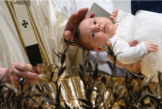 Pope Francis baptizes a baby as he celebrates Mass marking the feast of the Baptism of the Lord in the Sistine Chapel at the Vatican Jan. 9, 2022. The pope baptized 16 infants.