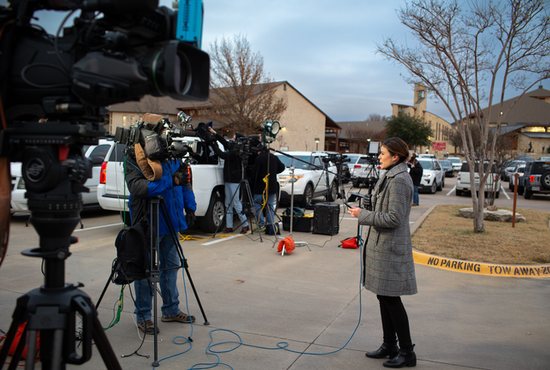 Local and national media, along with police, crowd the parking lot at Good Shepherd Catholic Church in Colleyville, Texas, Jan. 15, 2022, after four hostages were taken during services at nearby Congregation Beth Israel. After about an 11-hour standoff with an FBI crisis response team on the scene, the incident at the synagogue ended with the hostages' release and the hostage-taker being fatally shot.