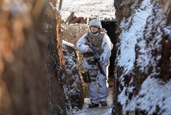 A service member of the Ukrainian armed forces walks in a trench at combat positions near the line of separation from Russian-backed rebels outside the settlement of Zaitseve in the Donetsk region of Ukraine Feb. 5, 2022.