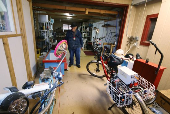 Vern Stuewe, 90, of Corvallis, Ore., walks amid bicycles and homemade trailers in his shop Jan. 21, 2022.